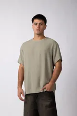 Remera color verde oliva de lino con textura entramada, cuello redondo y mangas cortas.