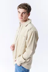 Sobrecamisa beige de pana con cuello clásico, cierre frontal con botones, mangas largas con puños abotonados y dos bolsillos de parche en el pecho.