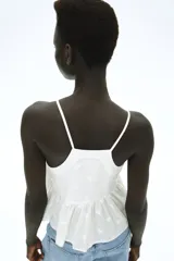 Top blanco de breteles finos, escote en V y peplum con leve vuelo.
