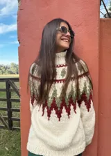 Sweater de lana color crudo con cuello alto y diseño geométrico en tonos verde y bordó.