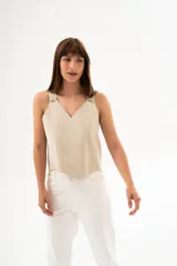 Chaleco color crema de cuero, con breteles gruesos y escote en V.