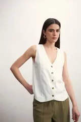 Chaleco negro de corte recto, sin mangas, con escote en V y cierre frontal de botones marrones.