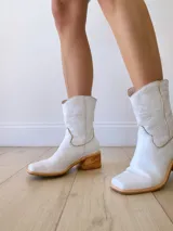 Botas texanas cortas de cuero color blanco, con caña media, punta cuadrada y taco de madera.