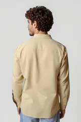 Camisa blanca de manga larga con cuello clásico y cierre frontal con botones.