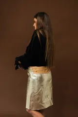 Falda midi plateada de cuero sintético, corte recto y tiro alto.
