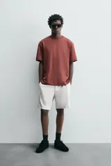 Camiseta blanca de algodón interlock con elasticidad, corte recto, cuello redondo y mangas cortas.