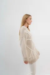 Sweater de mohair color crema con diseño de telaraña bordado a mano en negro.