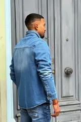 Sobrecamisa de jean celeste con bolsillos frontales con solapa y cierre con botones metálicos.