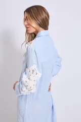 Vestido camisero celeste de lino con apliques de encaje blanco en cuello, mangas y frente.