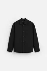 Camisa negra de corte regular fit confeccionada en tejido con viscosa. Tiene cuello solapa, manga larga con puño abotonado, bolsillo de parche en el pecho y cierre frontal con botones.