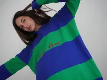 Sweater de hilo de algodón a rayas horizontales rosas y grises, con cuello polo, botones de guampa y bordado de Sierra Mora a tono.