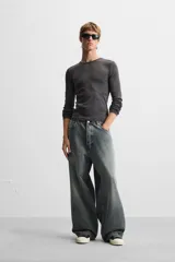 Pantalón de jean negro de corte amplio, con cinco bolsillos, efecto lavado y cierre frontal con cremallera y botón.