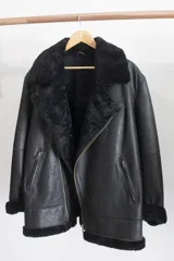 Gamulán negro oversize de cuero genuino con interior de piel sintética.