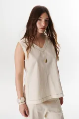 Top sin mangas confeccionado en mezcla de lino y algodón color marrón, con escote en V y pespuntes blancos decorativos en contraste.