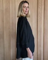 Camisa celeste de corte amplio, con cuello clásico y mangas largas.