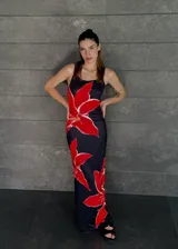 Vestido largo negro con estampado de flores rojas, de breteles finos y corte al cuerpo.