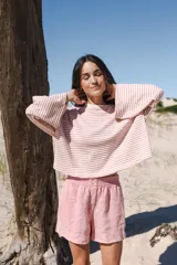 Remera oversize de algodón a rayas horizontales color rosa y blanco, con cuello redondo y mangas largas acampanadas.