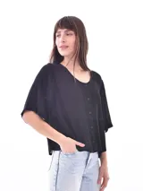 Blusa negra con cuello redondo y abotonadura frontal parcial. Tiene mangas cortas amplias y corte holgado.