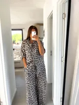 Conjunto de camisa de manga corta y pantalón palazzo acampanado con estampado de leopardo en tonos blanco, gris y negro.