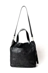Bolso tipo tote bag color negro con textura brillante, doble asa corta y correa larga desmontable. Tiene un bolsillo exterior y un bolsillo interior.