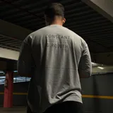 Remera gris de algodón, corte oversize, con estampado en la espalda con la frase "CONSTANT GROWTH" y la leyenda "Limited Edition - Only 10 Units".