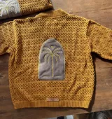 Saco de hilo color ocre con aplique de cuero bordado en la espalda con diseño de palmera.