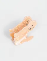 Broche de pelo color rosa claro con forma de perro y detalles en negro y amarillo.