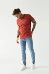 Remera gris de algodón con logo estampado en el pecho, cuello redondo y mangas cortas.