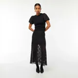 Camiseta negra entallada de tejido de punto acanalado, con cuello redondo y mangas cortas abullonadas de tela lisa.