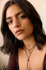 Dije plateado con forma de cráneo de toro con orificio en la frente.