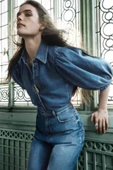 Blusa de denim con cuello solapa y manga abullonada por debajo del codo. Cierre frontal con botones.