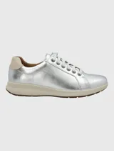 Zapatilla urbana de cuero color dorado, con cordones y suela blanca.