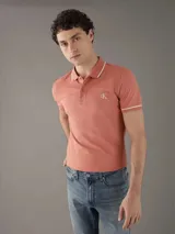 Chomba color salmón de corte slim fit, con cuello polo y mangas cortas con ribete blanco en contraste. Presenta logo CK bordado en el pecho. Confeccionada en mezcla de algodón y elastano.