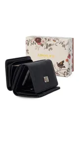 Billetera corta de símil cuero color beige claro, con cierre de broche a presión en la solapa principal. Presenta múltiples compartimentos internos para tarjetas y billetes, y un bolsillo exterior con cierre en la parte posterior. Lleva una placa metálica con el logo de la marca.