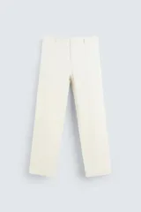 Pantalón color crudo, de corte recto, confeccionado en tejido de mezcla de algodón suave al tacto. Cuenta con bolsillos frontales y traseros de vivo con botón. Cierre frontal con cremallera y botón.
