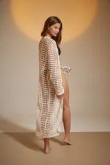 Saco largo de crochet color crudo, de corte holgado y cuello en V profundo.