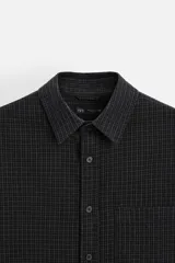 Camisa color crema de corte relaxed fit, confeccionada en tejido de mezcla de algodón suave al tacto. Tiene cuello solapa, manga larga con puños abotonados, un bolsillo de parche en el pecho y cierre frontal con botones.
