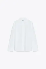 Camisa blanca de popelina de algodón, con cuello solapa y mangas largas con puños abotonados.