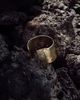 Brazalete ancho de bronce macizo con textura irregular.