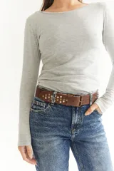 Cinto de cuero color marrón con hebilla metálica y tachas plateadas.