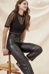 Polera negra de manga corta con cuello alto, confeccionada en tul transparente.