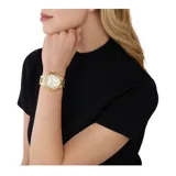Reloj Michael Kors modelo Camille, con caja y pulsera de acero inoxidable color dorado, esfera blanca con números romanos y tres subesferas.
