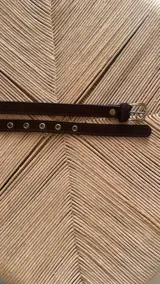 Cinturón delgado con estampado animal print y hebilla metálica dorada.