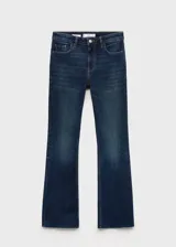 Pantalón de jean azul oscuro, tiro medio, corte flare y bajo deshilachado.