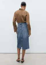 Falda midi de jean azul con corte evasé y terminación asimétrica.