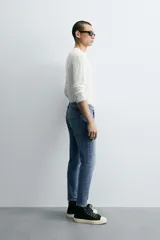 Pantalón de jean color beige, corte skinny, tiro medio, largo cropped y cinco bolsillos.