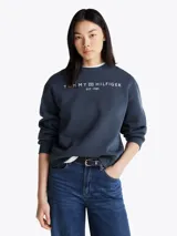 Buzo azul marino de Tommy Hilfiger con cuello redondo, corte regular y hombros caídos. Presenta el logo de la marca estampado en el pecho y detalles distintivos en la nuca y en la manga.
