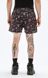 Short de baño negro con estampado de calaveras, dagas, serpientes, anclas y aves.