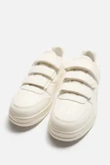 Zapatillas deportivas negras con triple cierre adherente, combinación de piezas en el corte y suela con ligero volumen. Diseño de inspiración retro.