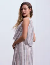 Vestido largo sin mangas, con estampado a rayas verticales en tonos beige, marrón y blanco. Tiene escote redondo y corte a la cintura con punto smock.